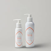 Two-bottles-of-Natural-Harmony-Body-and-Joint-Rub-on-a-light-gray-background