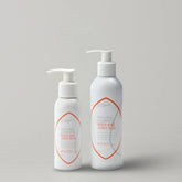 Two-bottles-of-Natural-Harmony-Body-and-Joint-Rub-on-a-light-gray-background