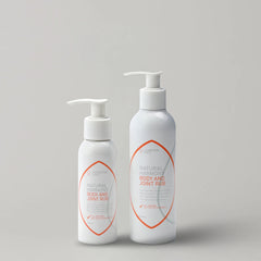 Two-bottles-of-Natural-Harmony-Body-and-Joint-Rub-on-a-light-gray-background