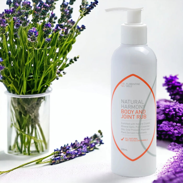 White bottle of 'Natural Harmony Body and Joint Rub' with lavender flowers on a white background